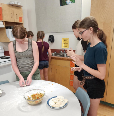 Girls in a kitchen making perogies