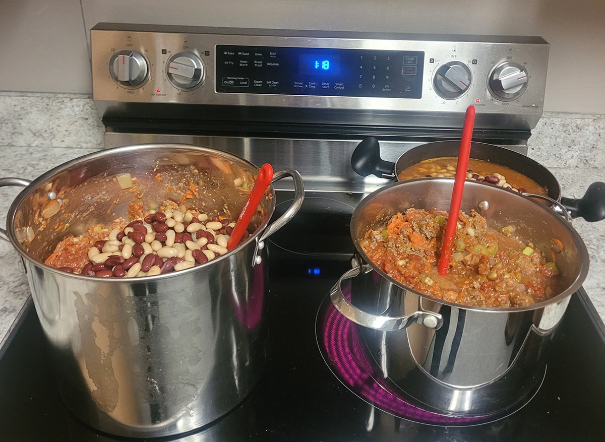 Chili and beans cooking on pots on the stove